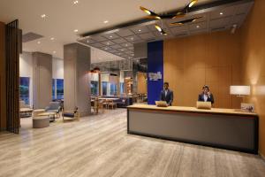 two people standing at a reception desk in a lobby at Holiday Inn Express Gurugram Sector 50, an IHG Hotel in Gurgaon