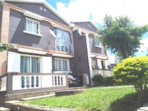 a black house with a porch and a tree at IVATO Airport STUDIOS CHAMBRES in Ivato