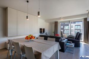 a dining room and living room with a table and chairs at Albert 0301 + garage in Koksijde