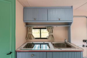 Beverley Thrills Caraglamping في ستراتفورد أبون آفون: مطبخ مع حوض ونافذة