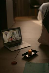 a candle on a plate with a laptop on the floor at ÑU Posta Urbana Hotel Boutique in Córdoba +27 photos