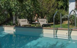 a swimming pool with two chairs and a table at Villa Galli in Calenzano