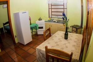 a kitchen with a table and a refrigerator at Sede Campestre Rincão do Coelho in Canela