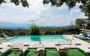 uma piscina com espreguiçadeiras e um visor de piscina em Villa Due Case em San Cristoforo a Perticaia