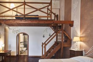 Cama elevada en un dormitorio con escalera en Casalta Boutique Hotel en Monteriggioni