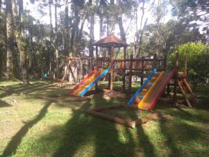 a playground with a colorful slide and an umbrella at Sede Campestre Rincão do Coelho in Canela