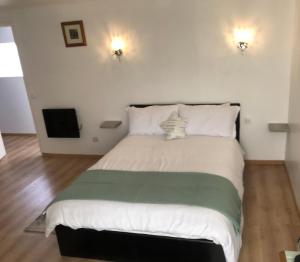 een slaapkamer met een groot bed met witte en groene lakens bij Lac du logerie in La Puye