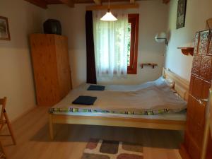 Dormitorio pequeño con cama y ventana en Hoffmann Vendégház, en Nagyrákos