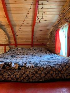 1 dormitorio con 1 cama en una cabaña de madera en Mandala Camping, en Faralya