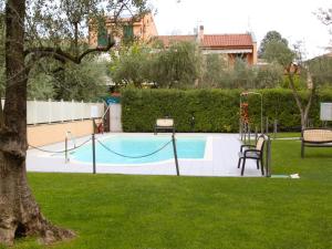 a pool in a yard with a swing at Apartment Il Piccolo by Interhome in Toscolano Maderno