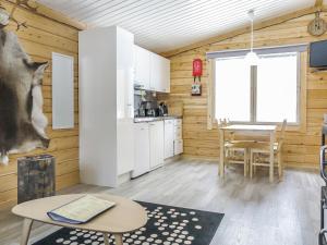 a kitchen and dining room with wooden walls and a table at Holiday Home Poromies b by Interhome in Saariselka
