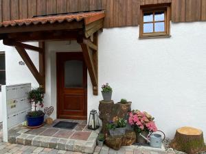 uma porta da frente de uma casa com vasos de plantas em Ferienwohnung Juliane em Holzkirchen