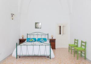 - une chambre avec un lit doté d'oreillers bleus et de 2 chaises dans l'établissement Casa Rosetta con terrazza panoramica by Wonderful Italy, à Ostuni