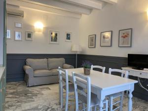 uma sala de estar com uma mesa e cadeiras e um sofá em Aduepassi apartments em Manfredonia