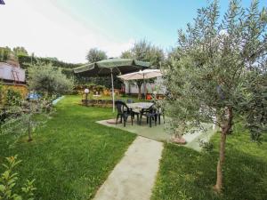 - un jardin avec une table et un parasol dans l'établissement Apartment Rondinelli by Interhome, à Pozzolengo