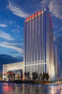 un gran edificio blanco con cruces rojas. en Wanda Realm Harbin Hotel en Harbin