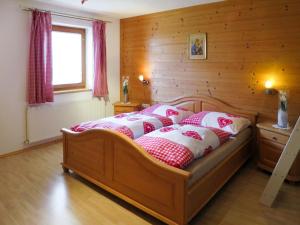 sypialnia z łóżkiem z białymi i czerwonymi poduszkami w obiekcie Apartment Marianne - FGZ163 by Interhome w mieście Hart im Zillertal