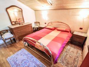 Schlafzimmer mit einem Bett, einer Kommode und einem Spiegel in der Unterkunft Apartment Santa Lucia-1 by Interhome in Valdisotto