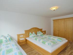 a bedroom with two beds with blue and green pillows at Holiday Home Hauser by Interhome in Mayrhofen