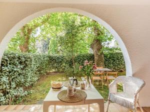 un arco con mesa y sillas en un jardín en Apartment Les Hauts de Bordagain-10 by Interhome, en Socoa