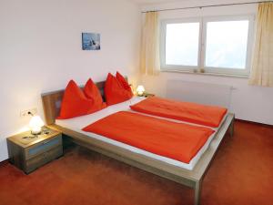 ツェル・アム・ツィラーにあるApartment Haus Huber - ZAZ404 by Interhomeのベッドルーム1室(赤い枕のベッド1台、窓付)