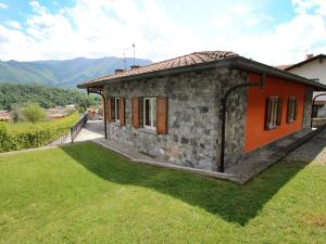 ein kleines Steinhaus mit einem grünen Hof in der Unterkunft Villa Lenno by Interhome in Lenno