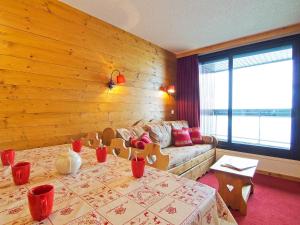 una sala de estar con una mesa y un sofá en Apartment Origanes 525 by Interhome, en Les Menuires