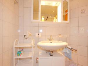 ein weißes Badezimmer mit einem Waschbecken und einem Spiegel in der Unterkunft Apartment Christian by Interhome in Ginzling