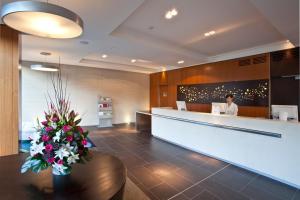 a lobby of a hotel with a reception desk and flowers at The Gateway Inn, Newcastle in Newcastle