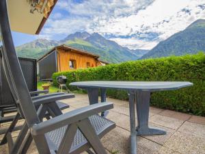 una mesa y sillas en un patio con vistas a las montañas en Apartment Weinberg by Interhome, en Pettneu am Arlberg
