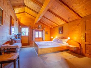 ein Schlafzimmer mit einem großen Bett und einer Holzdecke in der Unterkunft Chalet Waldner by Interhome in Thannrain