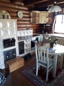 a kitchen with a white table and a table and chairs at Meseház Apartman in Zalalövő