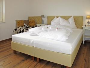 a large white bed with two white towels on it at Apartment Tamerl - MHO161 by Interhome in Schwendau