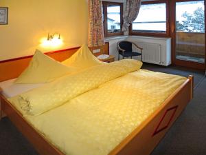 アシャウにあるApartment Haus Sonne - ZAZ683 by Interhomeのベッドルーム1室(大型ベッド1台、黄色い掛け布団付)