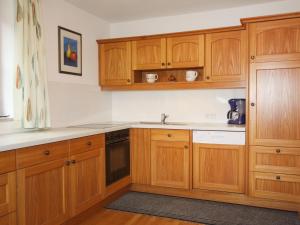 a kitchen with wooden cabinets and a sink at Holiday Home Schönhart by Interhome in Lippbauer