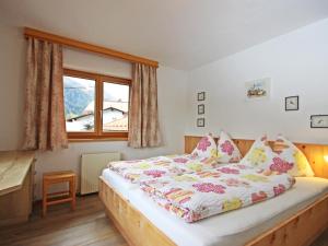 ein Schlafzimmer mit einem großen Bett und einem Fenster in der Unterkunft Apartment Werner by Interhome in Pettneu am Arlberg