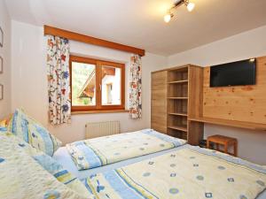 sypialnia z łóżkiem i telewizorem z płaskim ekranem w obiekcie Apartment Werner by Interhome w mieście Pettneu am Arlberg