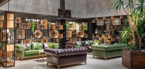 a library with green couches and shelves of books at MARINN DELUXE HOTEL in Yalova