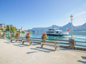 a boat on a lake with benches and a boat at Apartment Eckel-1 by Interhome in Russbach +11 photos