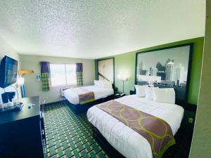 a hotel room with two beds and a large window at Super 8 Grand Rapids City Center in Wyoming