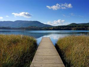 a wooden bridge over a lake with mountains in the background at La terraza in Banyoles