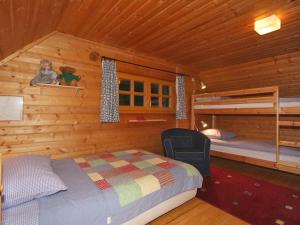 sypialnia w drewnianym domku z łóżkiem i łóżkiem piętrowym w obiekcie Chalet Neunhoeffer by Interhome w mieście Patergassen