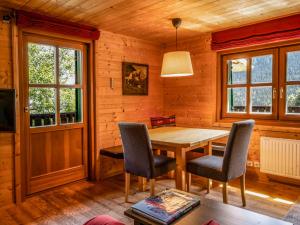 jadalnia z drewnianym stołem i krzesłami w obiekcie Chalet Neunhoeffer by Interhome w mieście Patergassen