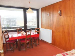 レ・メニュアールにあるApartment Aravis-3 by Interhomeのダイニングルーム(赤いテーブル、椅子、窓付)