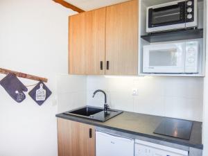 a kitchen with a sink and a microwave at Apartment La Boédette-1 by Interhome in Les Menuires