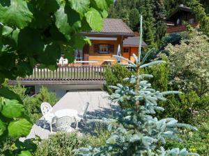 a garden with chairs and a house in the background at Chalet Eloise by Interhome in Nendaz