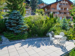 a patio with a table and chairs in a garden at Chalet Eloise by Interhome in Nendaz