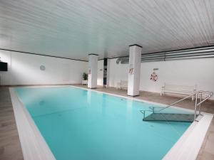 ein Pool mit blauem Wasser in einem Gebäude in der Unterkunft Apartment Alpenland-1 by Interhome in Seefeld in Tirol