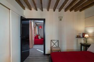 a bedroom with a red bed and a red couch at Luxury apartment in the heart of Genoa by Wonderful Italy in Genoa
