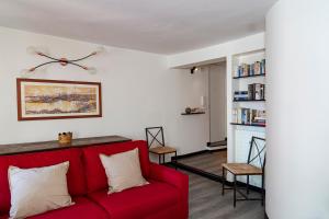 a living room with a red couch and a fireplace at Luxury apartment in the heart of Genoa by Wonderful Italy in Genova